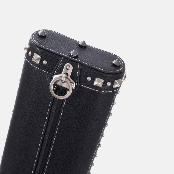 Black leather cue case with silver studs and ring on a white background