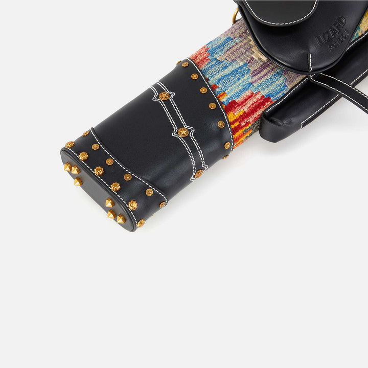 Close-up of a black cue case with colorful interior and gold studs on a white background